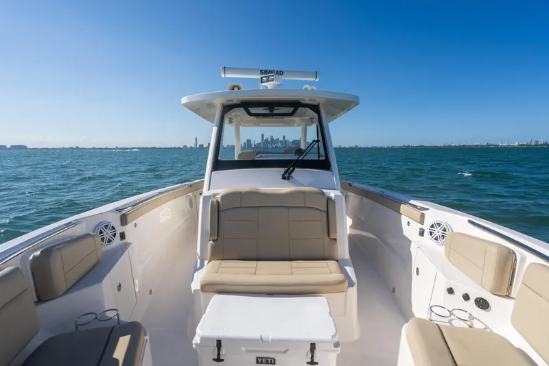 Slide: The Image of 2018 Pursuit S 328 Sport boat on open water with city skyline in background. - 44