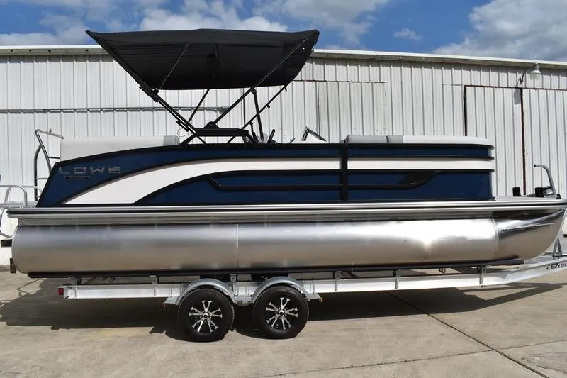 The Image of 2026 Lowe SS 230 WT Special pontoon boat on trailer, parked outdoors. - 1