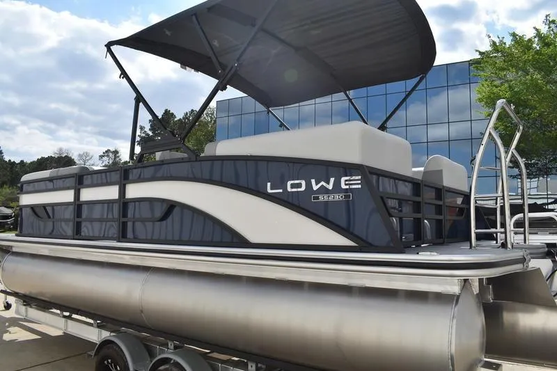 Slide: The Image of 2026 Lowe SS 230 WT Special pontoon boat with canopy, parked outdoors. - 7
