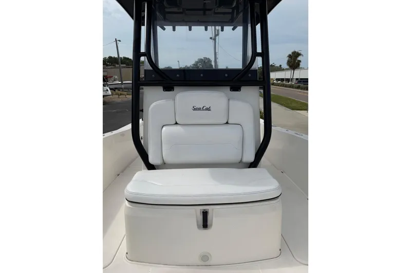 Slide: The Image of 2020 Sea Cat 260 boat with white seating and black frame, docked outdoors. - 15