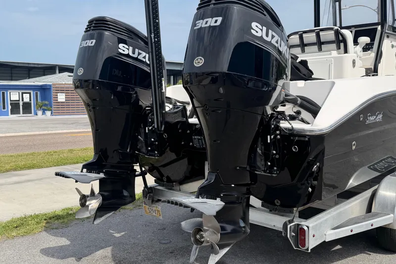 Slide: The Image of Twin Suzuki 300 engines on a 2020 Sea Cat 260 boat, parked on a trailer. - 23