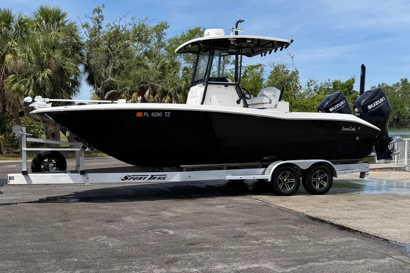 Slide: The Image of 2020 Sea Cat 260 boat on trailer with twin Suzuki engines, parked outdoors. - 5