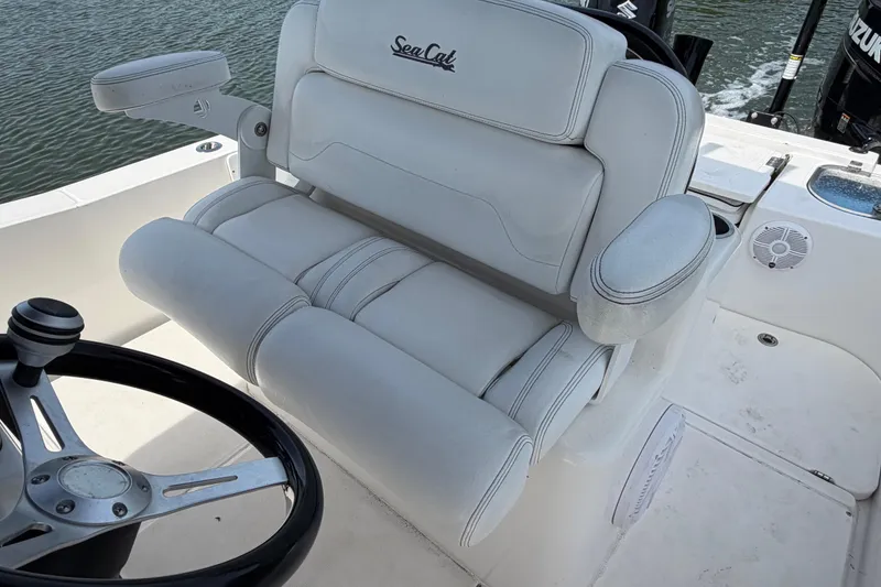 Slide: The Image of Captain's seat on 2020 Sea Cat 260 boat with steering wheel, on calm water. - 7