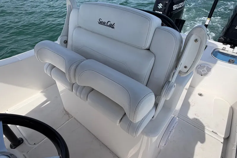 Slide: The Image of Captain's seat on 2020 Sea Cat 260 boat, featuring white upholstery and armrests. - 8