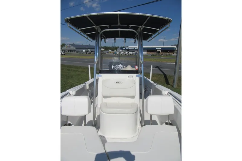 Slide: The Image of 2013 Sea Hunt Ultra 211 boat with T-top and seating, parked outdoors. - 10