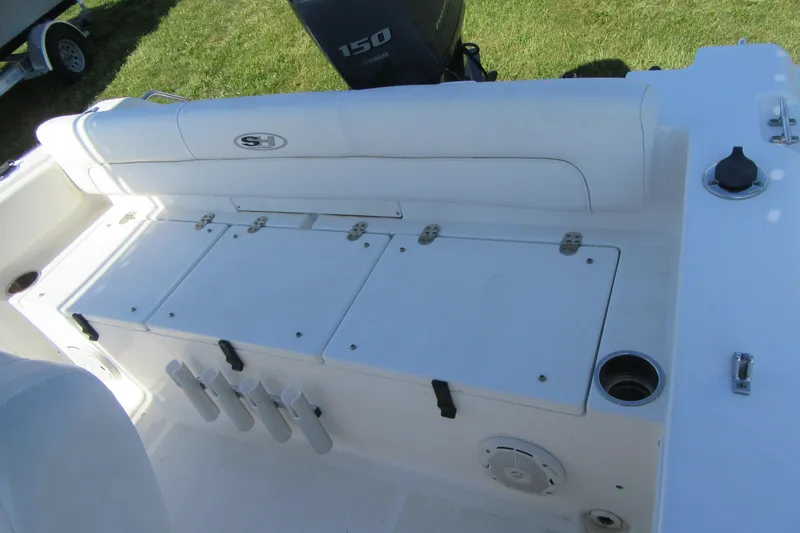 Slide: The Image of 2013 Sea Hunt Ultra 211 boat interior with storage compartments and rod holders. - 26