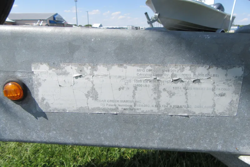 Slide: The Image of Weathered trailer label with orange reflector, Sea Hunt Ultra 211 boat in background. - 6