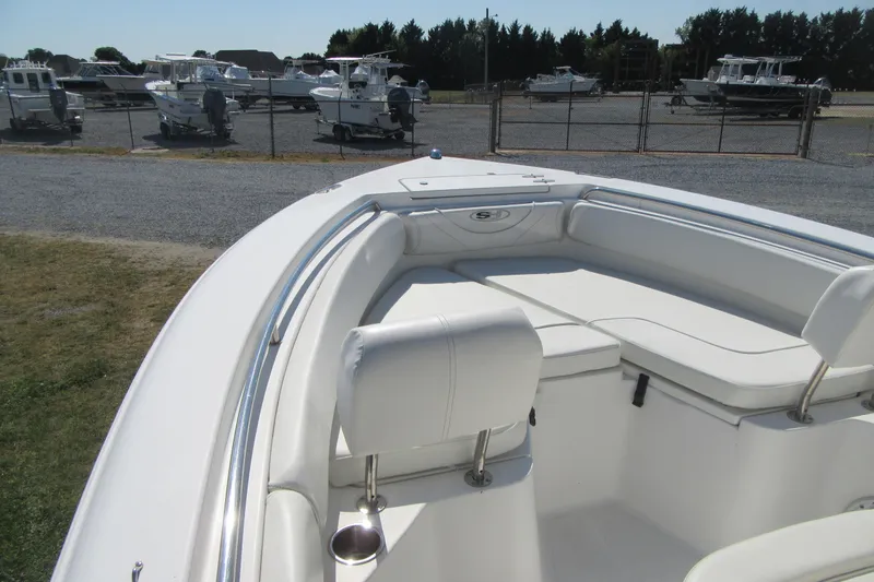 Slide: The Image of 2013 Sea Hunt Ultra 211 boat with white seating, parked in a marina. - 7