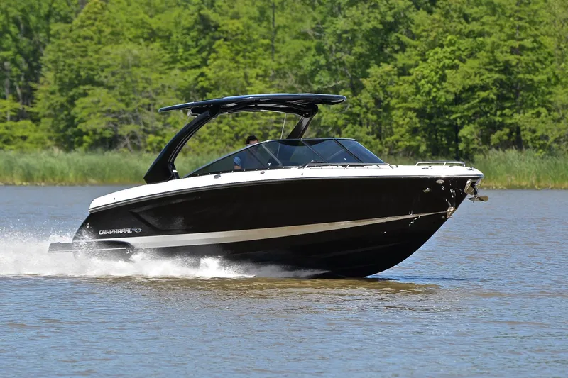 The Image of 2018 Chaparral 287 SSX speedboat cruising on a lake with lush green background. - 1