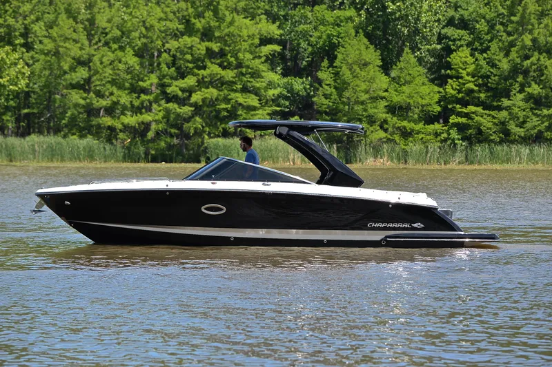 Slide: The Image of 2018 Chaparral 287 SSX boat cruising on a calm lake with lush green trees. - 10