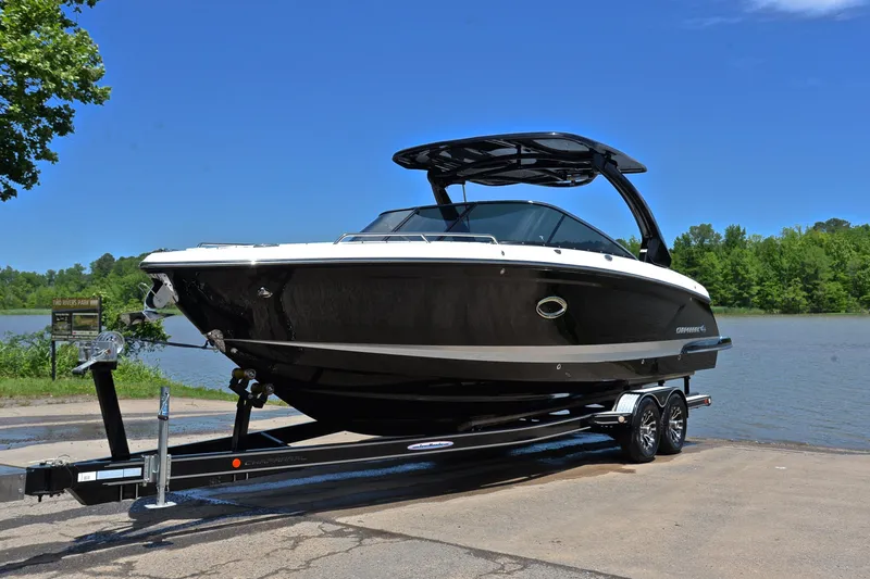 Slide: The Image of 2018 Chaparral 287 SSX boat on trailer by a lake under clear blue sky. - 11