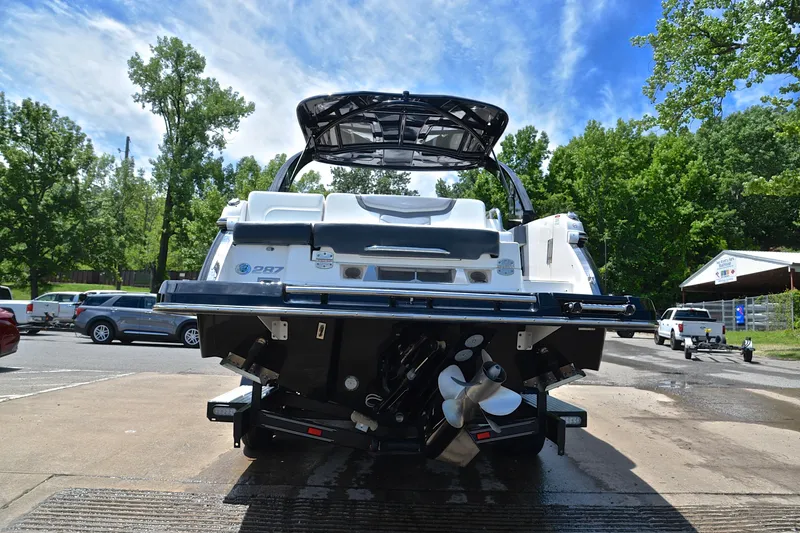 Slide: The Image of 2018 Chaparral 287 SSX boat at dock, rear view with lush greenery background. - 14
