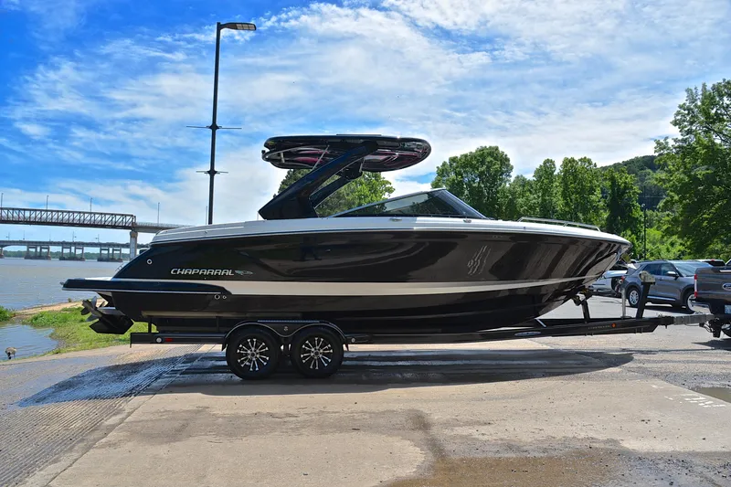 Slide: The Image of 2018 Chaparral 287 SSX boat on trailer by riverside, under blue sky. - 16