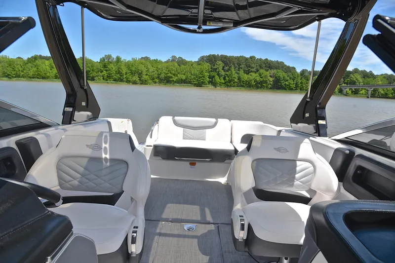 Slide: The Image of 2018 Chaparral 287 SSX boat interior with luxurious seating on a serene lake. - 23