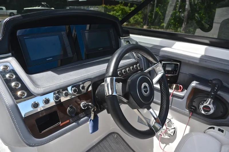 Slide: The Image of 2018 Chaparral 287 SSX boat dashboard with steering wheel and navigation screens. - 29