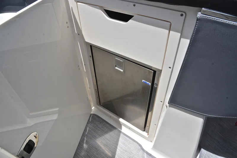 Slide: The Image of Interior view of 2018 Chaparral 287 SSX boat featuring a built-in stainless steel refrigerator. - 31