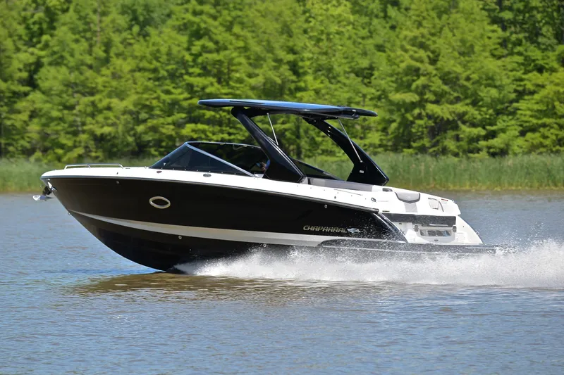 Slide: The Image of 2018 Chaparral 287 SSX boat cruising on a lake with lush green trees. - 4