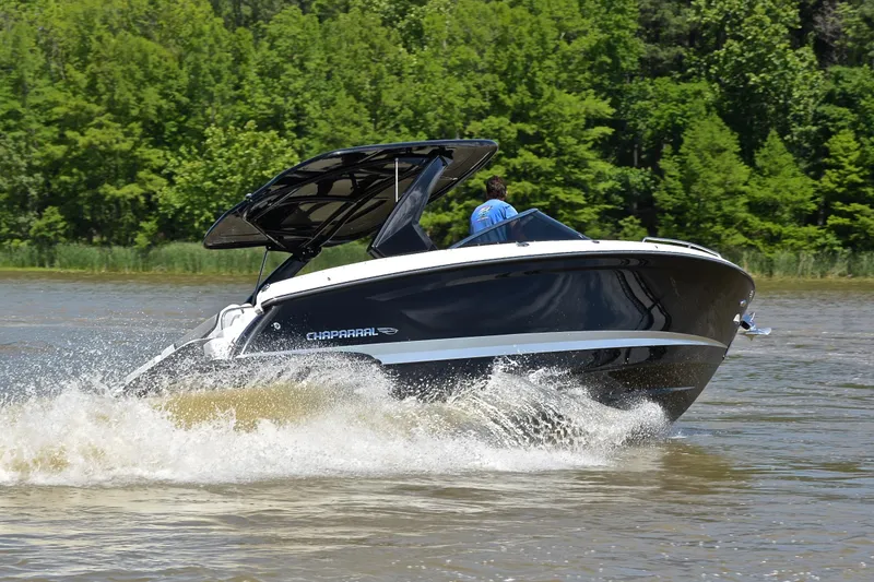 Slide: The Image of 2018 Chaparral 287 SSX boat cruising on a lake with lush green trees. - 5