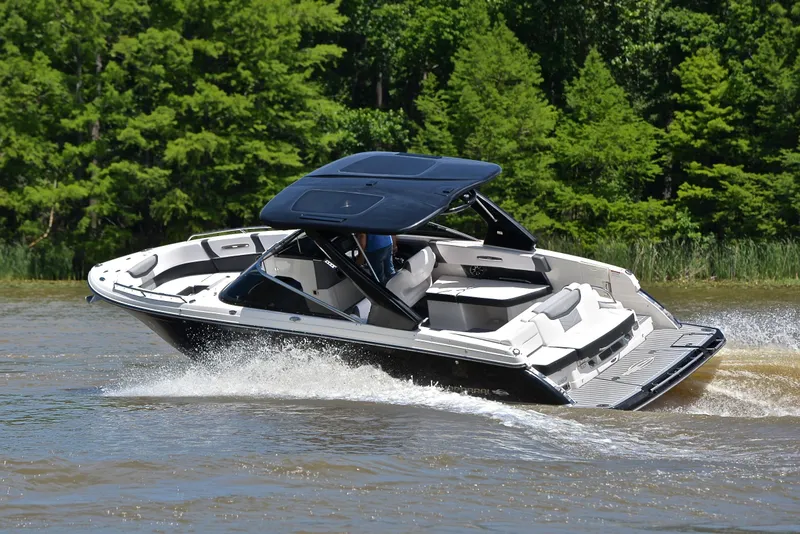 Slide: The Image of 2018 Chaparral 287 SSX boat cruising on a lake with lush green trees. - 7