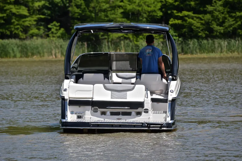 Slide: The Image of 2018 Chaparral 287 SSX boat cruising on a calm lake with lush greenery. - 9
