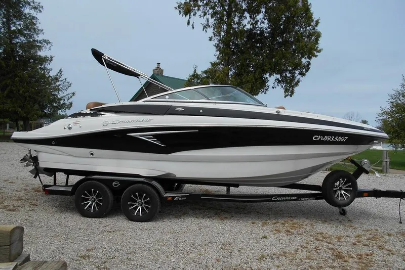 The Image of 2024 Crownline Eclipse E235 boat on trailer, parked outdoors. - 1
