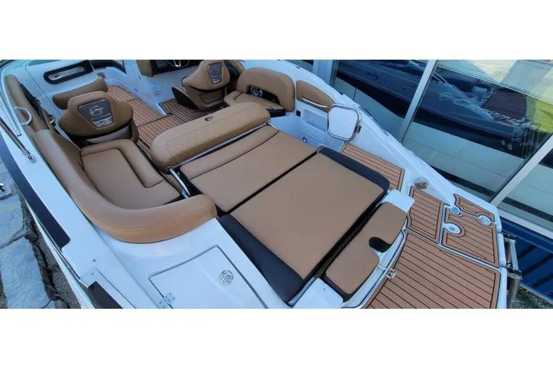 Slide: The Image of 2024 Crownline Eclipse E235 boat interior with tan seating and wood accents. - 10