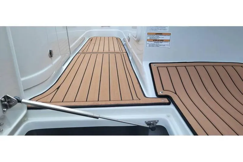 Slide: The Image of 2024 Crownline Eclipse E235 boat deck with sleek wood finish and modern design. - 12