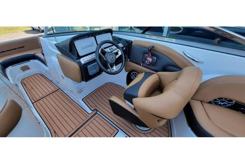 Slide: The Image of 2024 Crownline Eclipse E235 boat interior with tan seating and Garmin navigation system. - 13