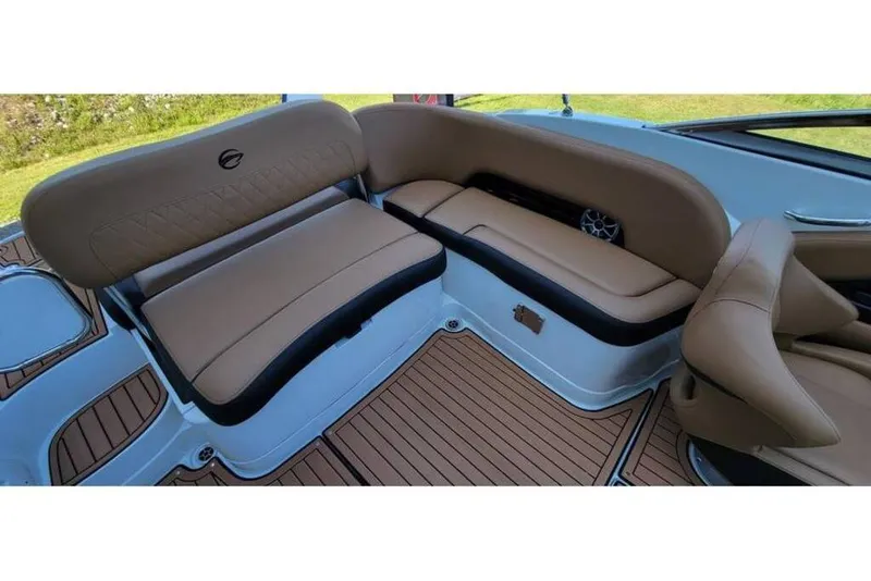 Slide: The Image of 2024 Crownline Eclipse E235 boat interior with tan seating and wood-style flooring. - 19