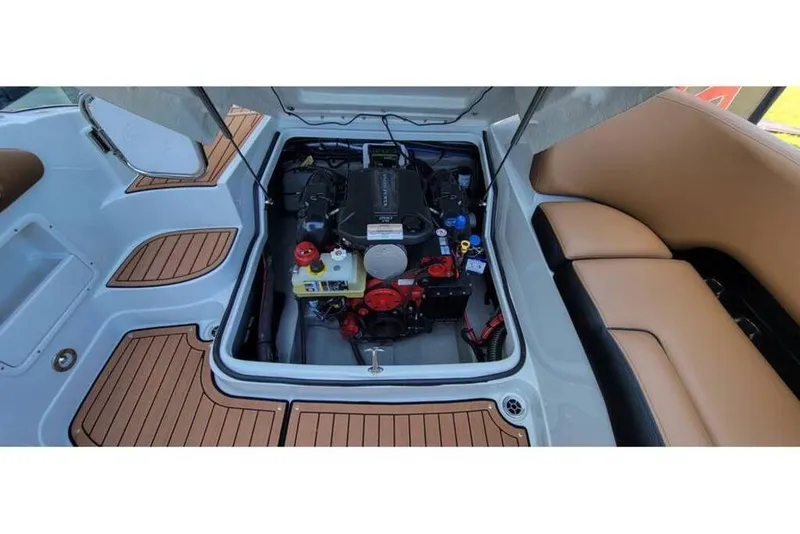Slide: The Image of 2024 Crownline Eclipse E235 boat engine compartment with tan seating and teak flooring. - 20