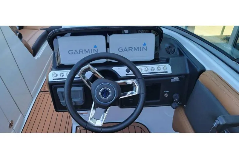 Slide: The Image of 2024 Crownline Eclipse E235 dashboard with Garmin navigation system and sleek steering wheel. - 24