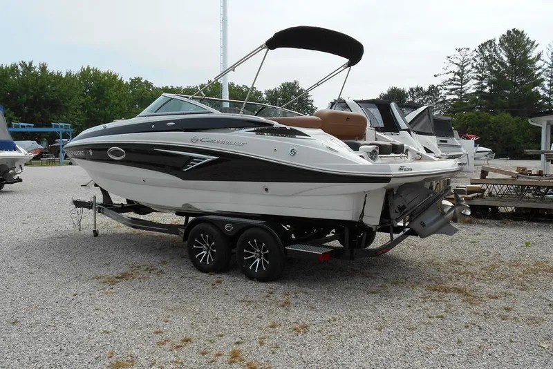 Slide: The Image of 2024 Crownline Eclipse E235 boat on trailer, parked outdoors, featuring sleek design and black accents. - 3