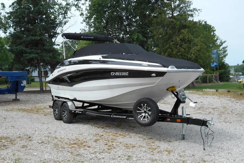 Slide: The Image of 2024 Crownline Eclipse E235 boat on trailer, parked outdoors. - 4