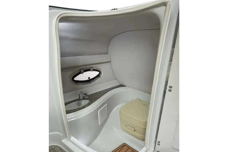 Slide: The Image of 2024 Crownline Eclipse E235 boat interior with compact bathroom and porthole window. - 9