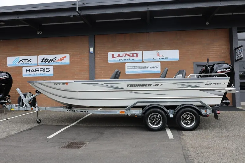 The Image of 2025 Thunder Jet 209 Rush OT boat on trailer, parked outside dealership. - 0