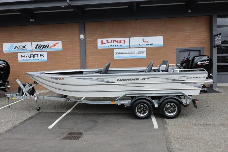 Slide: The Image of 2025 Thunder Jet 209 Rush OT boat on trailer, parked outside dealership. - 16