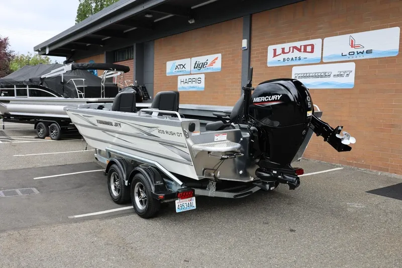 Slide: The Image of 2025 Thunder Jet 209 Rush OT boat with Mercury engine in dealership lot. - 17