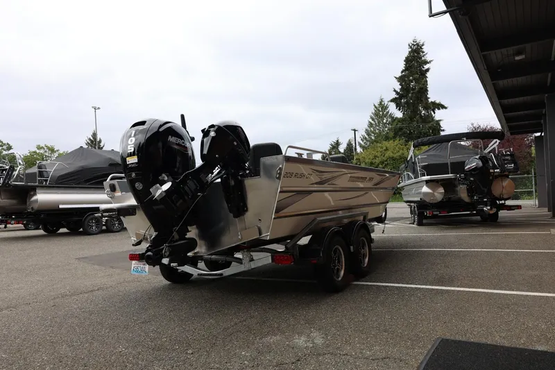 Slide: The Image of 2025 Thunder Jet 209 Rush OT boat with Mercury engine in parking lot. - 24