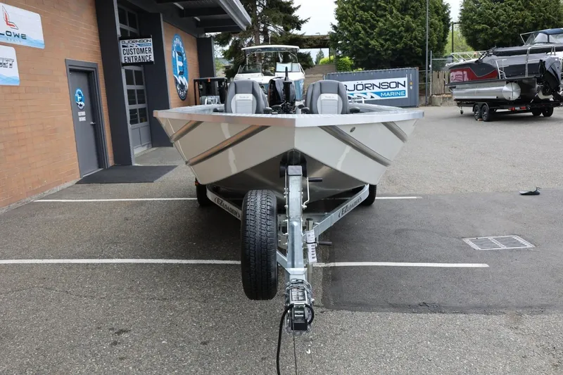 Slide: The Image of 2025 Thunder Jet 209 Rush OT boat on trailer at dealership entrance. - 27