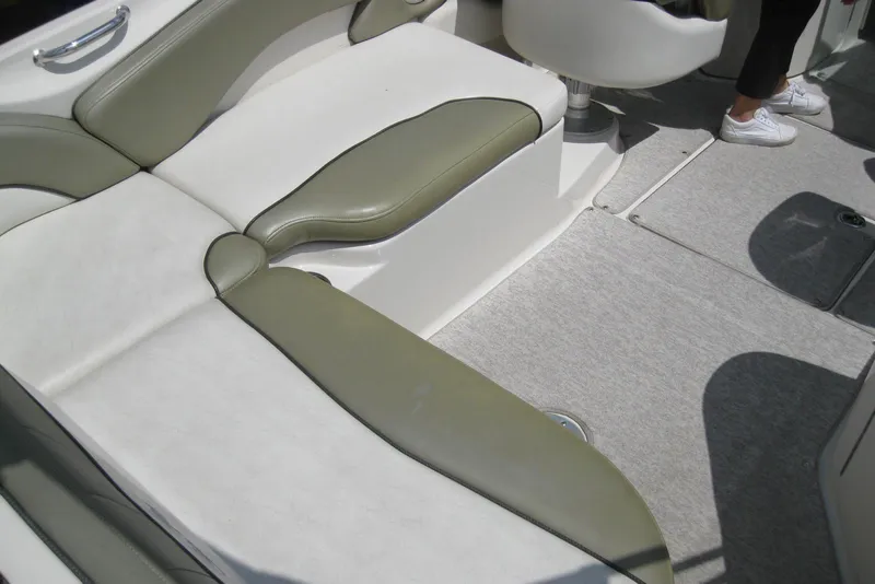 Slide: The Image of 2006 Sea Ray 240 Sundeck interior with white and olive seating, carpeted floor. - 10