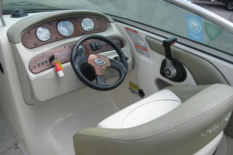 Slide: The Image of Steering console of a 2006 Sea Ray 240 Sundeck boat with gauges and controls. - 14