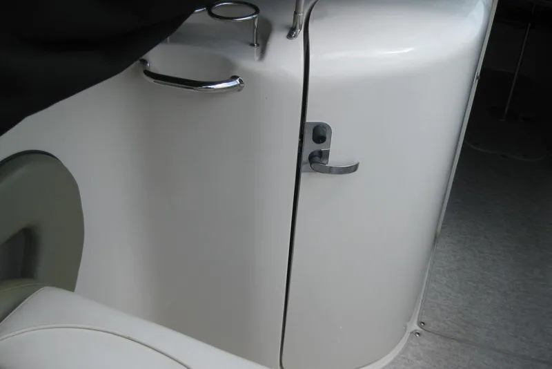 Slide: The Image of Interior view of a 2006 Sea Ray 240 Sundeck boat, featuring a cabin door and seating. - 15