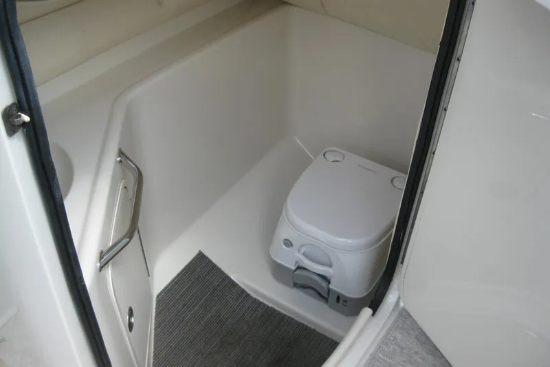 Slide: The Image of 2006 Sea Ray 240 Sundeck boat interior with compact marine toilet. - 16