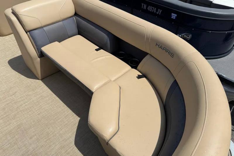 Slide: The Image of 2023 Harris Cruiser 230 boat interior with beige seating and cup holders. - 4