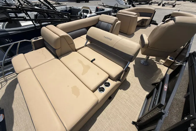 Slide: The Image of 2023 Harris Cruiser 230 boat interior with beige seating and cup holders. - 6