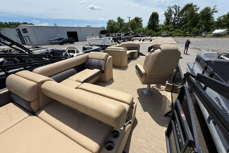 Slide: The Image of 2023 Harris Cruiser 230 pontoon boat with beige seating, parked outdoors. - 7