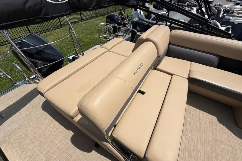 Slide: The Image of 2023 Harris Cruiser 230 boat with beige seating and Mercury engine. - 8