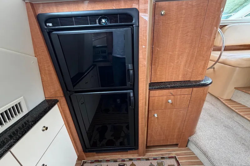 Slide: The Image of 2001 Maxum 4600 SCB yacht interior with wood cabinetry and black refrigerator. - 30