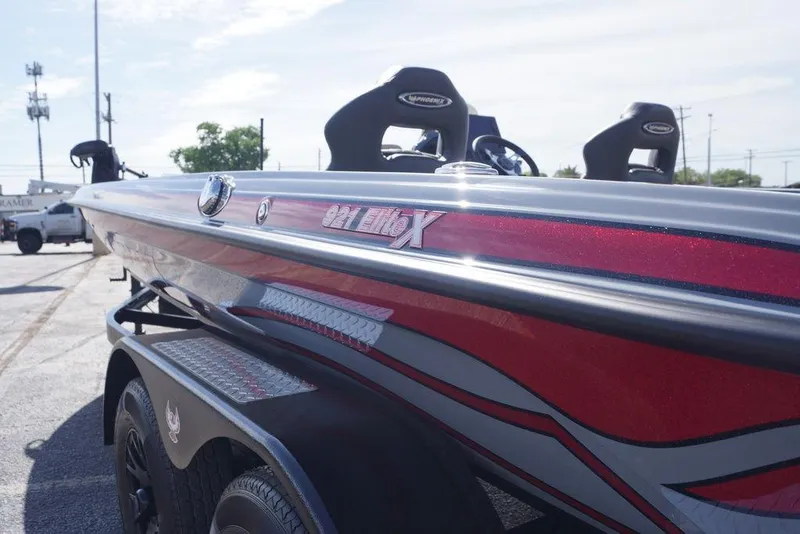 Slide: The Image of 2026 Phoenix 921 Elite X boat with sleek red and silver design on trailer. - 13