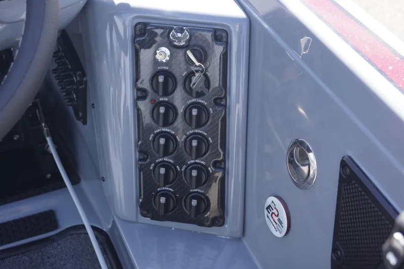 Slide: The Image of Control panel of 2026 Phoenix 921 Elite X boat with switches and key ignition. - 20